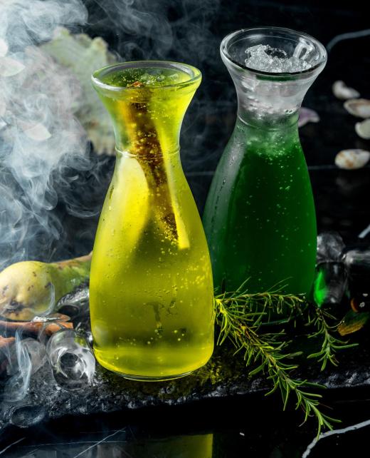 a glass bottle with pear cocktail with pear slices